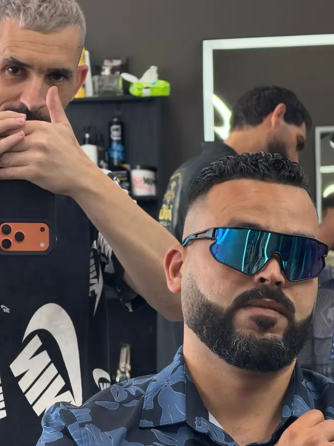 A barber working a line-up at the chair